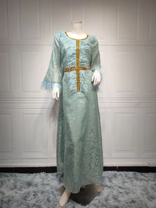 Elegantes hellblaues langes Kleid mit Goldprägung und Federdetails auf Schaufensterpuppe