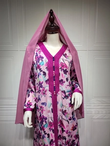 Detail of floral printed maxi dress with intricate pink embroidery and matching veil