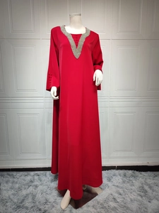 Detail der roten Abaya mit V-Ausschnitt, Silberperlen und geknöpften Ärmelbündchen