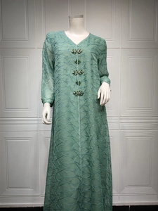 Close-up of mint green embroidered mesh dress featuring exquisite rhinestone flower buttons