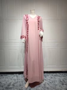 Detail of red leaf embroidery on a pink chiffon abaya dress with a V-neck design