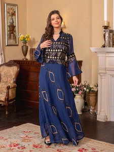Detail of navy kaftan dress featuring gold sequin embroidery and tassel sleeve fringe