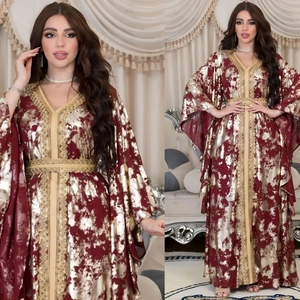 Detail of burgundy kaftan dress with gold foil texture, V-neck embroidery and tassel sleeves