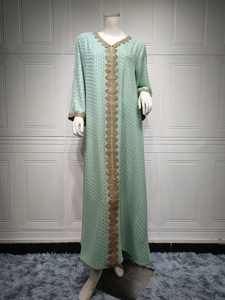 Detail der schweren Stickerei auf mintgrünem Kaftan mit goldener Folienpunkt-Muster