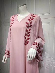 Close-up of deep red leaf embroidery on a pink chiffon long-sleeved dress