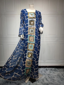 Close-up of deep blue kaftan dress with colorful sequins and wavy chiffon patterns