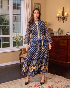 Dettaglio di un kaftano blu navy con ricami dorati e cintura decorativa con nappe