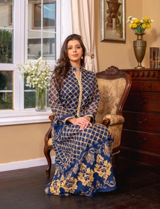 Abito caftano blu navy con ricami dorati e bottoni su un'elegante sedia vintage raffinata
