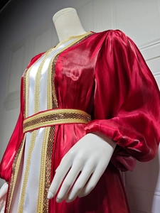 Detail of red kaftan dress with golden sequin embroidery and silky white lining