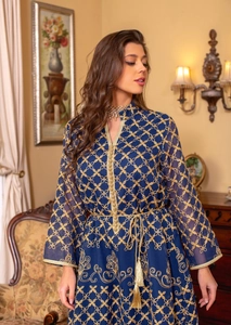 Dettaglio dell'abito tunica ricamato blu navy con finiture dorate e cintura con nappe