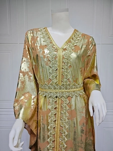 Macro detail of gold embroidery on apricot chiffon kaftan dress with foil print