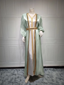 Detail of luxury green satin kaftan with intricate gold sequin embroidery and cuffed sleeves