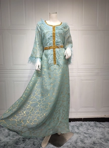 Nahaufnahme des hellblauen Kleides mit goldenem Gittermuster und elegantem Federbesatz