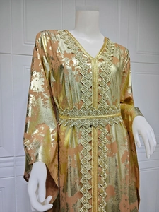 Detail of gold foil patterns on yellow chiffon caftan with embroidered trim and belt