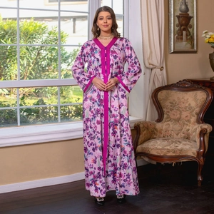 Elegant floral print kaftan dress in fuchsia pink with decorative ribbon trim and long sleeves