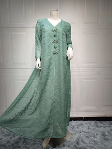Detail view of light green mesh dress featuring geometric embroidery and crystal buttons