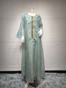 Detail von hellblauem Kleid mit Goldnetzmuster, Federbesatz und Goldpailletten-Kanten