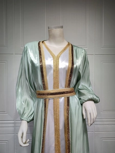 Detailed embroidery and sequins on the collar of a light green satin kaftan dress