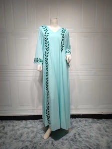 Detailed view of dark green leaf embroidery on light blue chiffon abaya dress