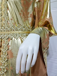 Close-up of gold foil pattern and beaded metallic lace on orange chiffon dress