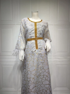Detailansicht des goldenen Netzmusters und der eleganten weißen Federn am grauen Kleid