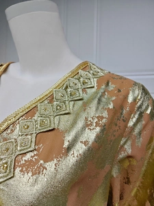 Detail of peach pink chiffon dress with gold foil print and beaded embroidery