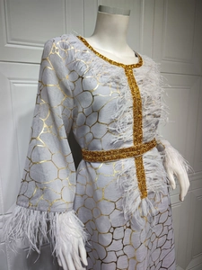 Detail eines grauen Kleides mit goldenen Rissmustern und edlem weißen Federbesatz