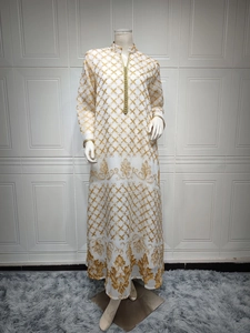 Dettaglio del ricamo dorato e del colletto intrecciato su un abito lungo abaya bianco