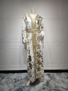 Detail of V-neck white kaftan dress with gold foil print and geometric embroidery