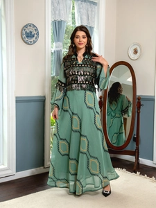 Detail of green evening dress with sequins, fringe embroidery and ethnic geometric patterns