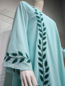 Detail of green leaf embroidery and silver thread on light blue chiffon abaya sleeve