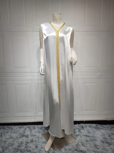 Detail of elegant white satin long dress featuring luxurious gold braided V-neck embroidery