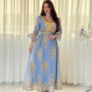 Close-up of golden floral embroidery and sequins on light blue long evening dress