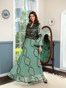 Detailed embroidery and black sequins with tassels on a mint green evening dress