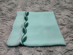 Close-up of light blue chiffon hijab featuring intricate dark green leaf embroidery edges