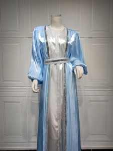 Detail of luxury light blue kaftan with silver sequin trim and satin texture