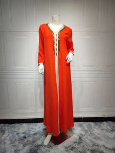 Close-up of the V-neck detail with gold beadwork and woven trim on orange long dress