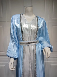Detail of sky blue satin kaftan dress featuring luxury sequins and lantern sleeves