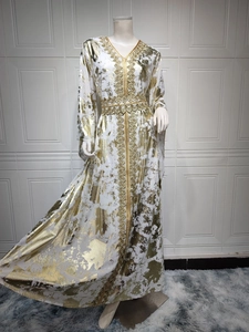 Detail of white chiffon kaftan dress with gold foil print and geometric embroidery