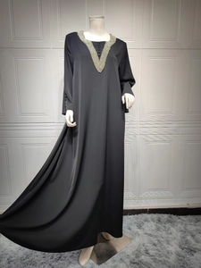 Detailansicht des schwarzen Abaya-Kleids mit V-Ausschnitt, Perlenstickerei und Knöpfen