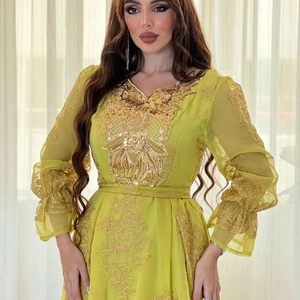 Detailed close-up of golden embroidery and sequins on lime green ethnic evening dress