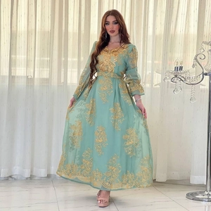 Close-up of intricate gold floral embroidery on mint green evening kaftan dress