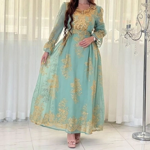 Detail view of mint green dress with intricate gold embroidery and sequin patterns