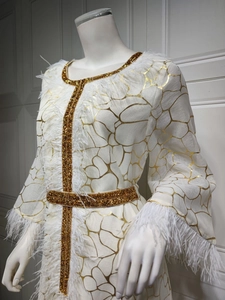 Detailansicht des weißen Kaftans mit goldenen Mustern und luxuriösen Federbesatz-Details