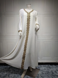 Detail eines weißen Abaya-Kleids mit goldener Goldfolie und buntem geometrischem Muster