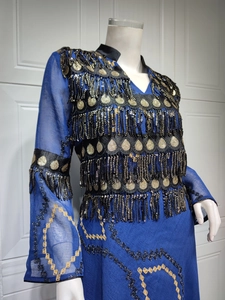 Detail of royal blue evening dress featuring black sequin tassels and golden embroidery