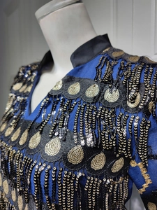 Detail of royal blue evening dress with golden sequins, embroidery and fringe tassels