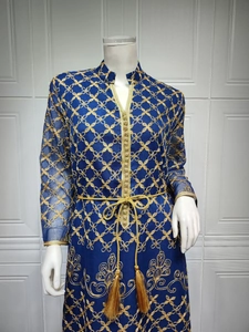 Dettaglio di un caftano blu navy con ricami dorati e cintura con nappine