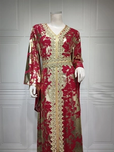 Detailed view of the gold foil print and intricate embroidery on this red kaftan dress