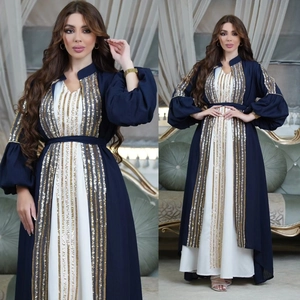 Detail of blue and white kaftan with lantern sleeves and vertical gold sequins
